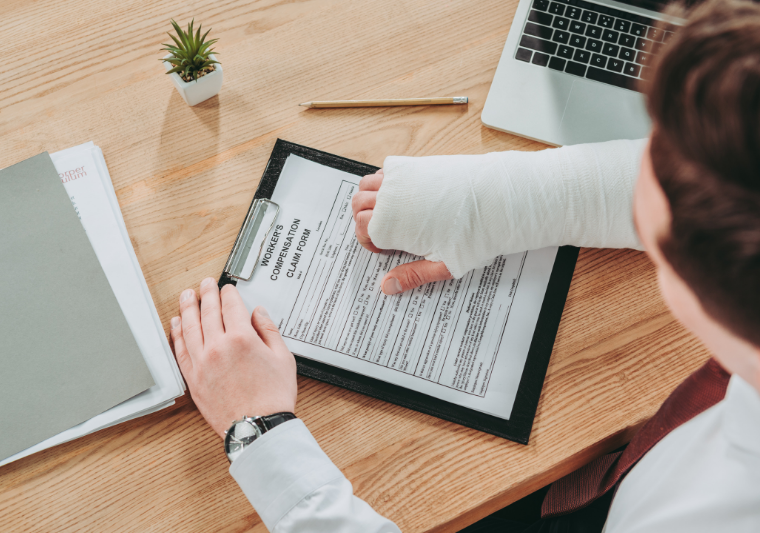 person with hand in cast filling out workers compensation form