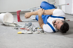 Worker on the ground after falling from a ladder at a construction site