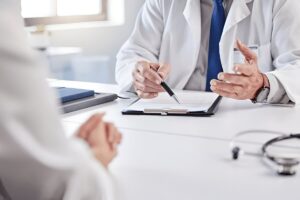 Hands, doctor and patient with consultation in clipboard for medical history