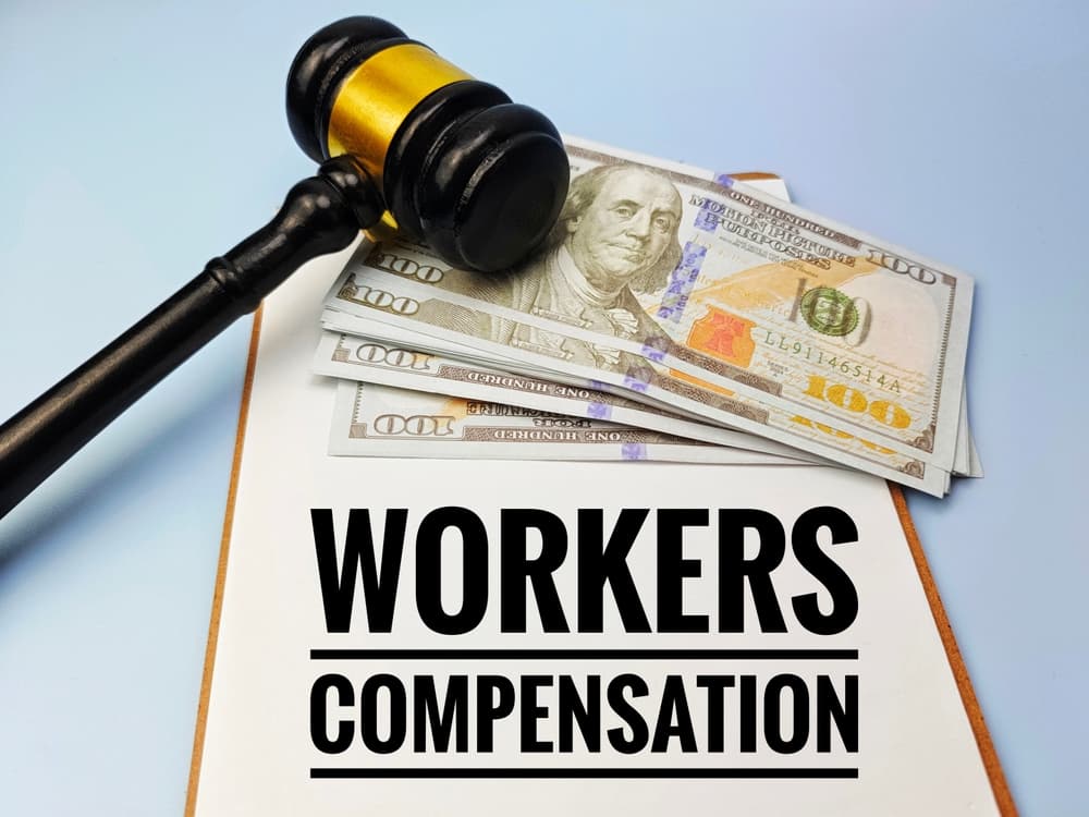 Gavel and cash on a Workers Compensation folder illustrating benefits available to part-time warehouse workers injured on the job in Indiana.